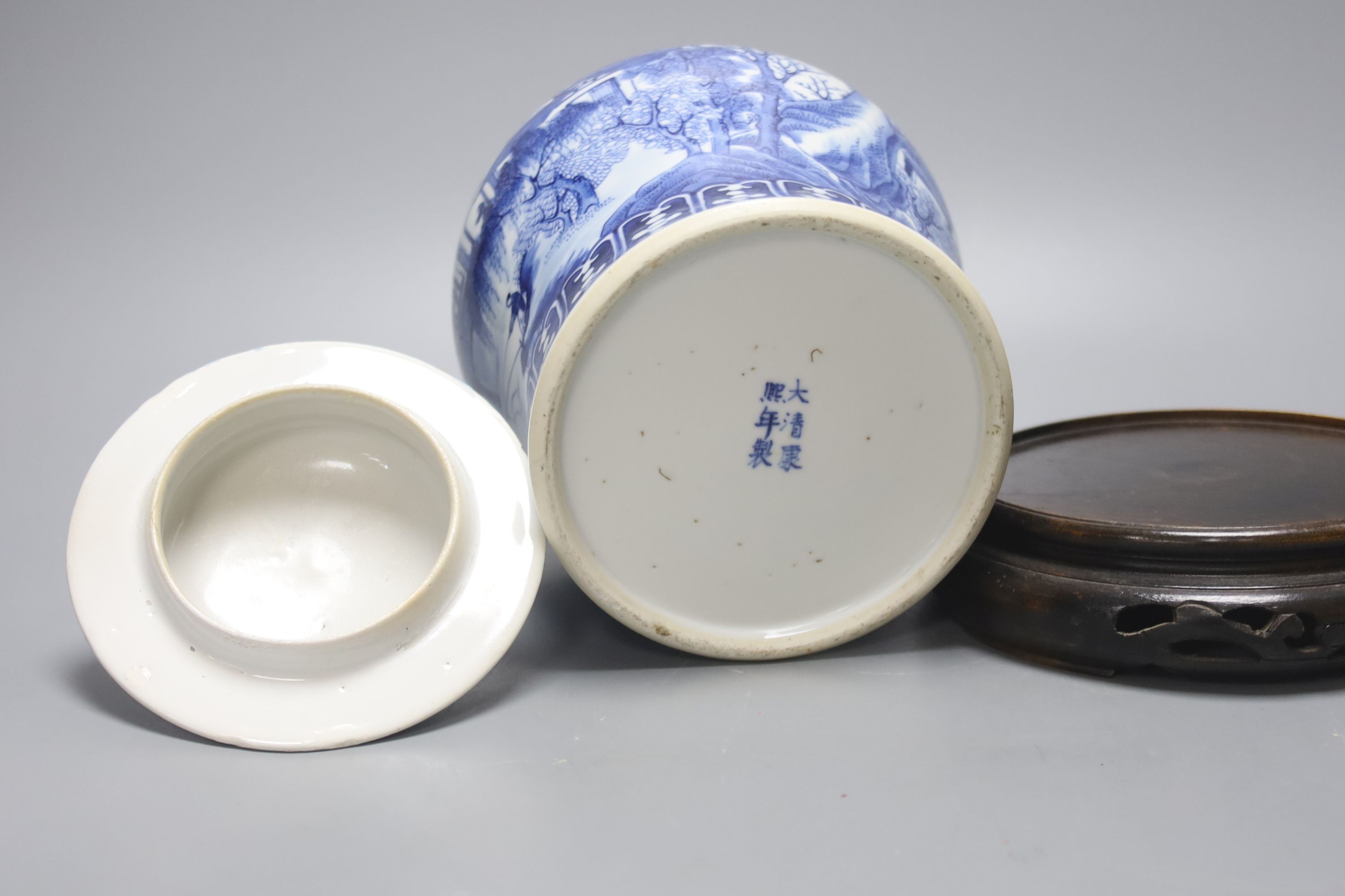 A late 19th / early 20th century Chinese blue and white landscape jar and cover, wood stand 30cm total height